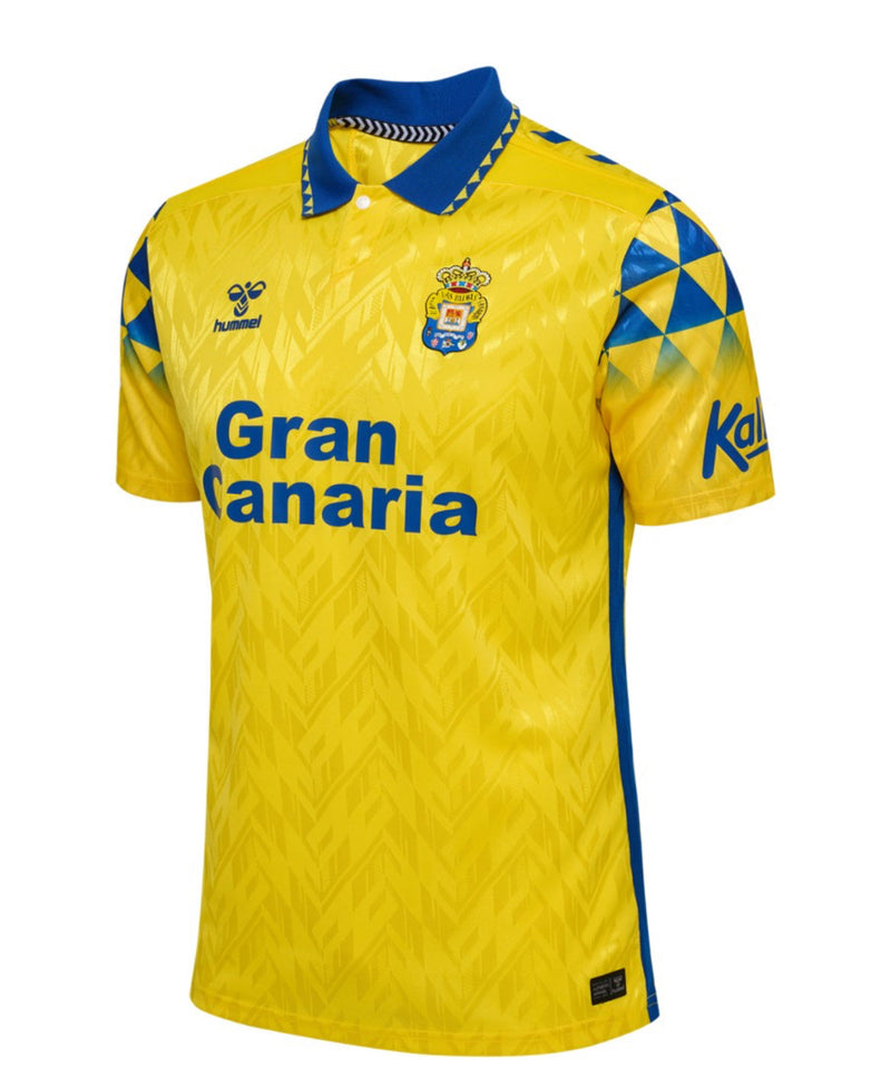 '- Camiseta - de - fútbol - amarilla - con - detalles - azules
- Temporada - 24-25
- Tipo - de - camiseta - Casa
- Marca - Hummel
- Equipo - U.D. - Las - Palmas
- La - camiseta - tiene - el - logotipo - de - Hummel - en - el - pecho - y - el - escudo - del - equipo - en - el - lado - izquierdo - del - pecho.
- La - camiseta - también - tiene - el - nombre - del - equipo - "Gran - Canaria" - en - el - pecho. 