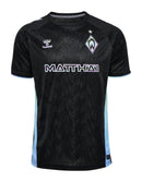 Werder Bremen - 2024/2025 - Camiseta Werder Bremen - Uniforme alternativo Werder Bremen - Hummel Werder Bremen - Diseño moderno - Negro - Verde - Amarillo - Bundesliga - Copa de Alemania - Patrón gráfico abstracto - Identidad del club - Gola redonda - Escudo del club - Logo de Hummel - Patrocinio WIESENHOF - Tecnologías innovadoras - Confort - Rendimiento. 