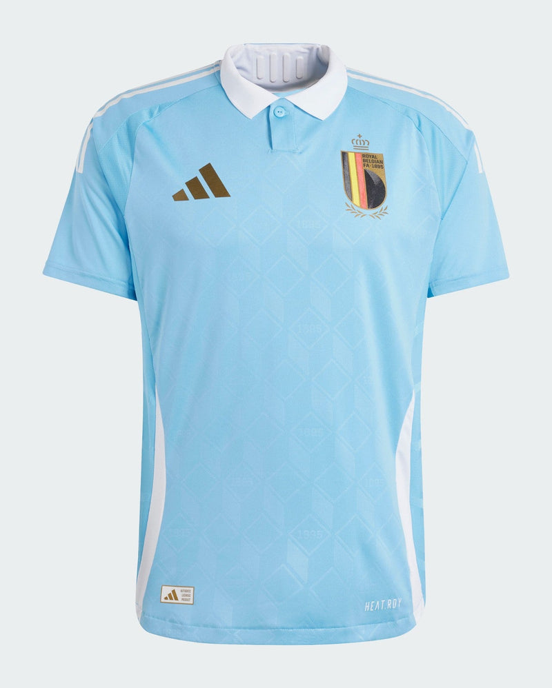 Bélgica - 2024/2025 - Camiseta Bélgica - Uniforme alternativo Bélgica - Adidas Bélgica - Diseño Tintín - Azul celeste - Eurocopa - Nations League - Eliminatorias Copa del Mundo - Cuello polo blanco - Patrón jacquard - Logo de la federación - Logo de Adidas - Escudo de la Royal Belgian FA - Tecnologías innovadoras - Confort - Rendimiento - Homenaje - Historia - Identidad - Pantalón marrón - Calcetines blancos.