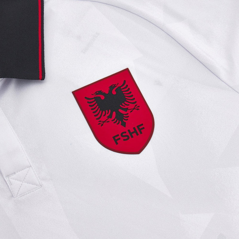 Albania - 2023/2024 - Camiseta Albania - Uniforme alternativo Albania - Macron Albania - Diseño clásico - Blanco y negro - Eliminatorias Eurocopa - Águila de dos cabezas estilizada - Gola polo - Escudo Federación Albanesa - Logo de Macron - Pantalón blanco - Calcetines blancos - Historia - Identidad - Tecnologías innovadoras - Confort - Rendimiento.