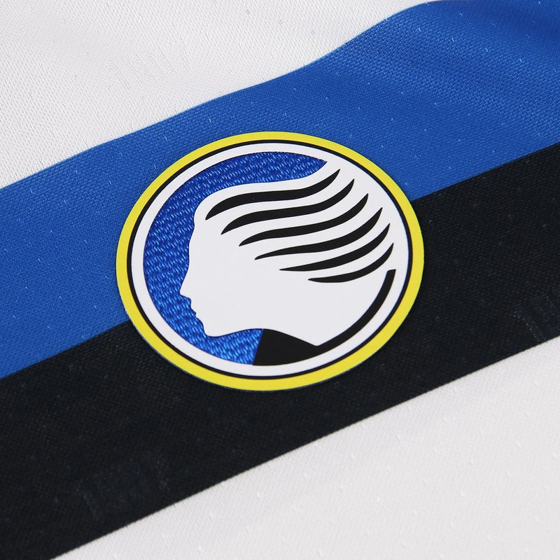 Atalanta 2024/2025 - Camiseta alternativa Atalanta - Joma Atalanta - Serie A - Coppa Italia - Champions League - Diseño clásico - Detalles en azul y negro - Blanco - Azul - Negro - Identidad del club - Historia - Gola redonda - Escudo del Atalanta - Logo de Joma - Tecnologías innovadoras - Confort - Rendimiento.