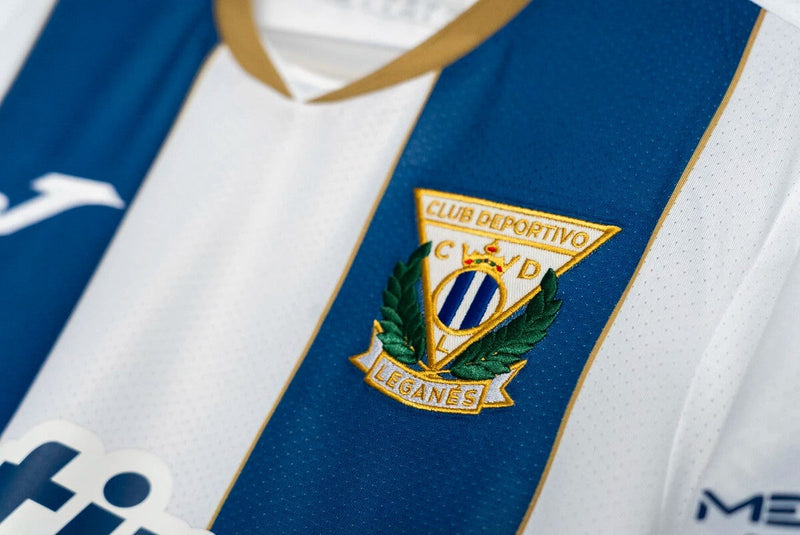 Leganés 2024/2025 - Camiseta Leganés - Uniforme titular Leganés - Joma Leganés - LaLiga EA Sports - Diseño clásico - Diseño moderno - Azul - Blanco - Negro - Gola redonda - Escudo del Leganés - Logo de Joma - Identidad del club - Historia del club - Tecnologías innovadoras - Confort - Rendimiento.